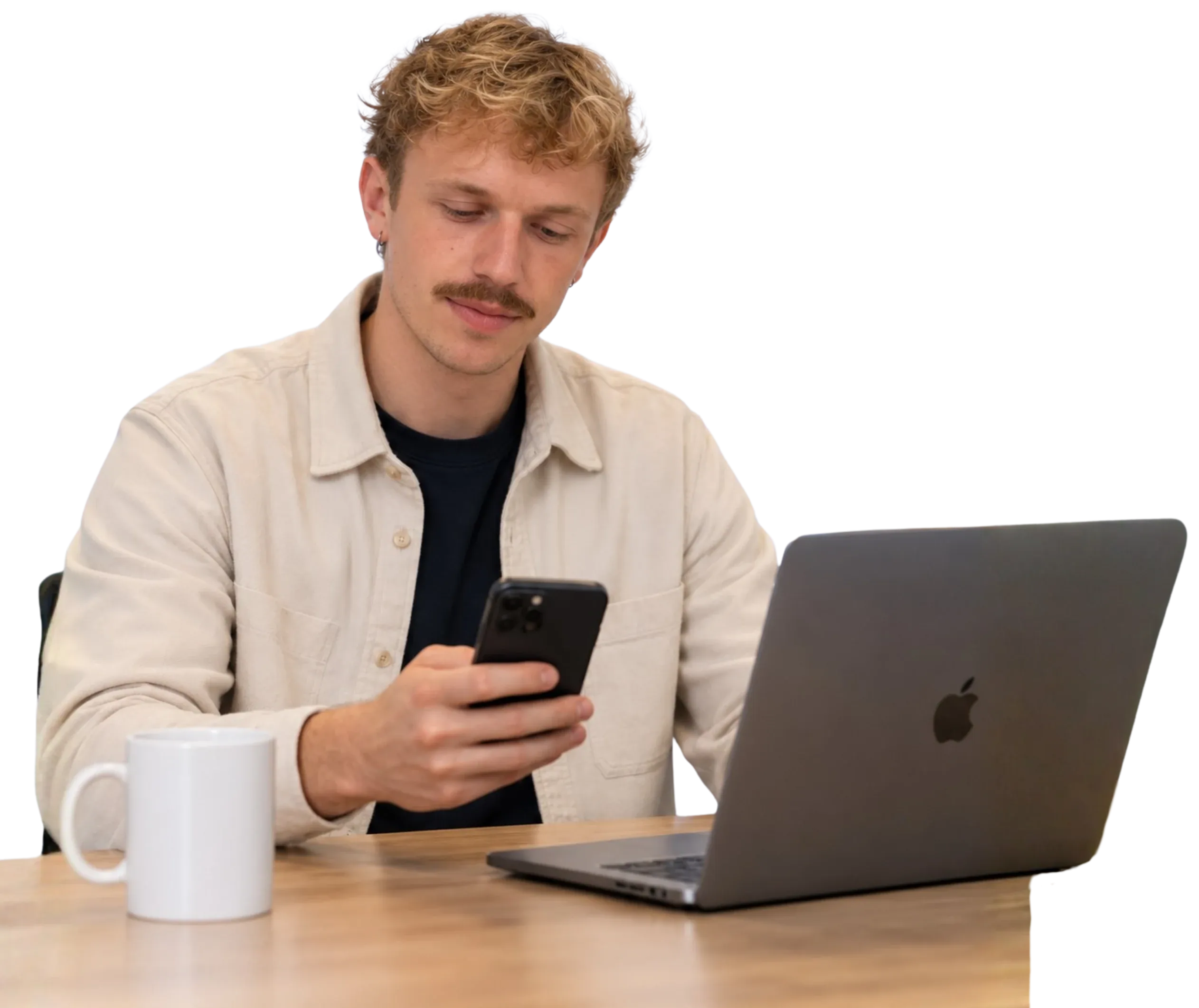 Timo, medeoprichter van Traffic To Talks, aan tafel met zijn telefoon en een opengeklapte laptop